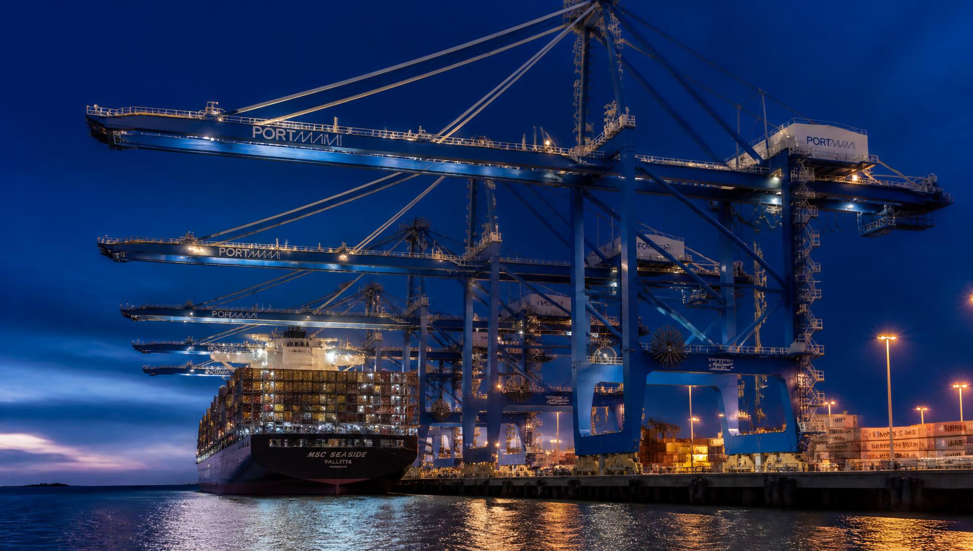 Ship-to-shore gantry cranes working a container vessel at PortMiami at dusk